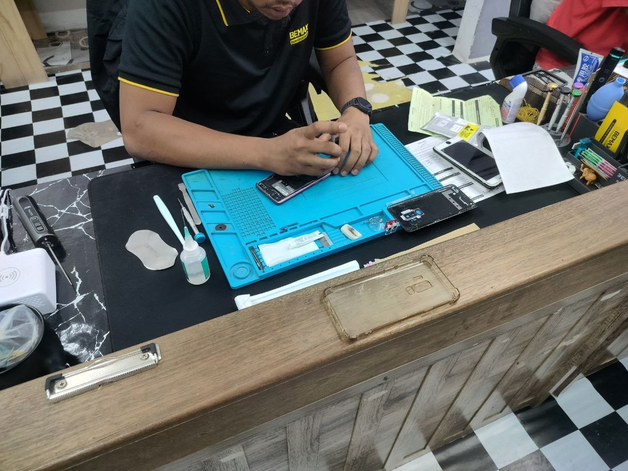 Technichian sedang membaiki telefon