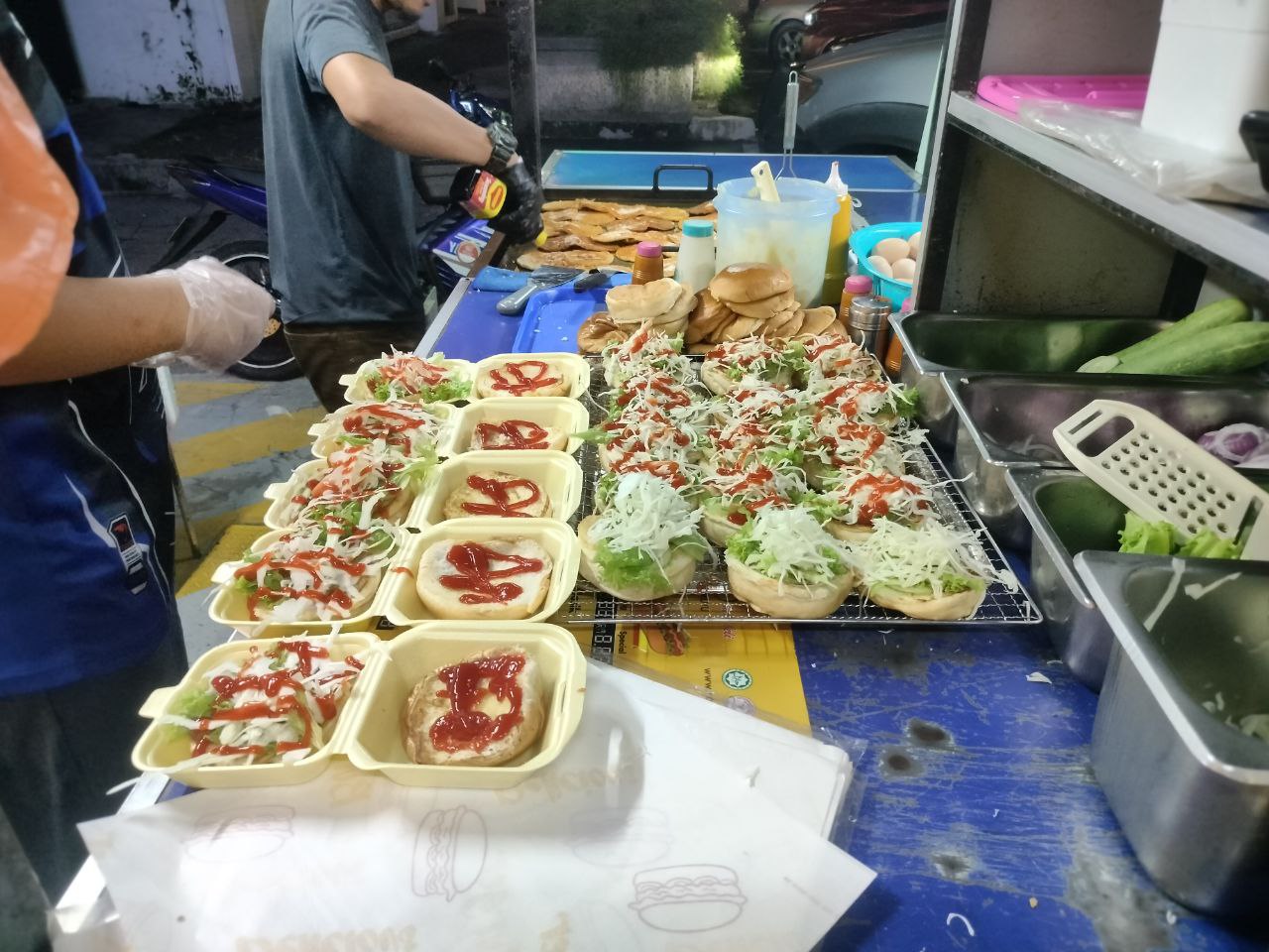 Gambar tukang masak sedang menyediakan burger