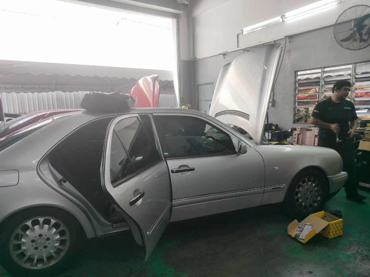 Foremen sedang membaiki kereta Mercedes-Benz model W210